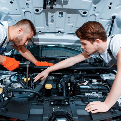 7 They can fix anything. Two handsome car mechanics in uniform checking the engine under hood in the car service station